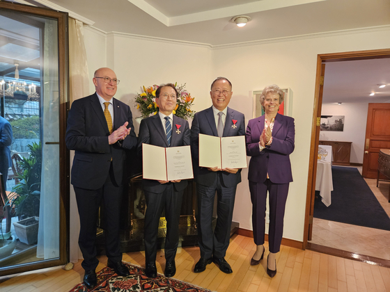 Sabine Haag, director general of the Kunsthistorisches Museum, far right, and Austrian Ambassador to Korea Wolfgang Angerholzer, far left, present the Austrian Decoration for Science and Art on behalf of the federal president of Austria to Yoon Sung-yong, director-general of the National Museum of Korea, center left, and Kim Jung-ho, president and CEO of the Korea Economic Daily, center right, at the Austrian diplomatic residence in Seoul on Friday. [EMBASSY OF AUSTRIA TO KOREA]