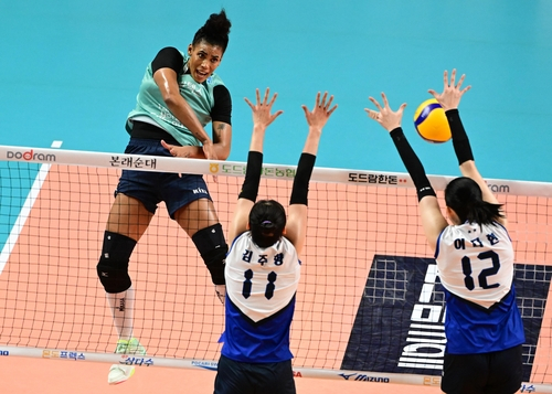 The GS Caltex Seoul Kixx's Gyselle Silva, left, attacks during a V League game against Suwon Hyundai Engineering & Construction Hillstate at Jangchung Arena in central Seoul on Friday. [YONHAP] 