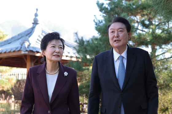 President Yoon Suk Yeol, right, walks alongside former President Park Geun-hye as they view her garden at her residence in Dalseong County, Daegu, Tuesday. [PRESIDENTIAL OFFICE]