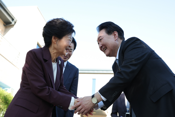 President Yoon Suk Yeol, right, shakes hands with former President Park Geun-hye at Park's residence in Dalseong County, Daegu, Tuesday. [PRESIDENTIAL OFFICE]