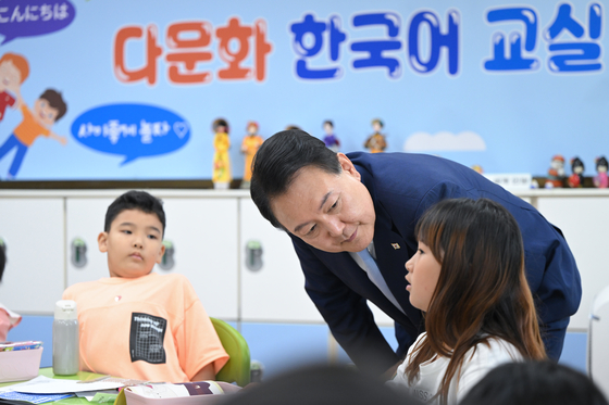 President Yoon Suk Yeol talks with a multicultural student taking Korean language learning course at Suwon Elementary School in Gyeonggi on July 3. [NEWS1]