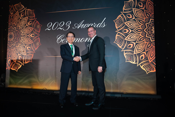 Kyobo Life Insurance Chairman Shin Chang-jae, left, shakes hands with Josh Landau, president of the International Insurance Society, after Shin accepts the reward as the 2023 Insurance Hall of Fame Laureate in Singapore on Monday. [KYOBO LIFE INSURANCE]