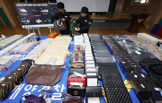 This photo from Tuesday shows fake products of foreign brands confiscated by the police. The crime ring responsible for smuggling more than 50,000 boxes of luxury goods, valued at 1.5 trillion won ($1.1 billion), into the country, has been apprehended by the Incheon Coast Guard. While the authorities have seized approximately 600 boxes of counterfeit products, the rest is believed to have already made their way into the domestic market. [YONHAP]
