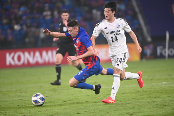 Ulsan Hyundai's Lee Gyu-sung, right, vies for the ball with Johor Darul Ta'zim's Oscar Arribas during an AFC Champions League match at Sultan Ibrahim Stadium in Malaysia on Tuesday. [AFC]