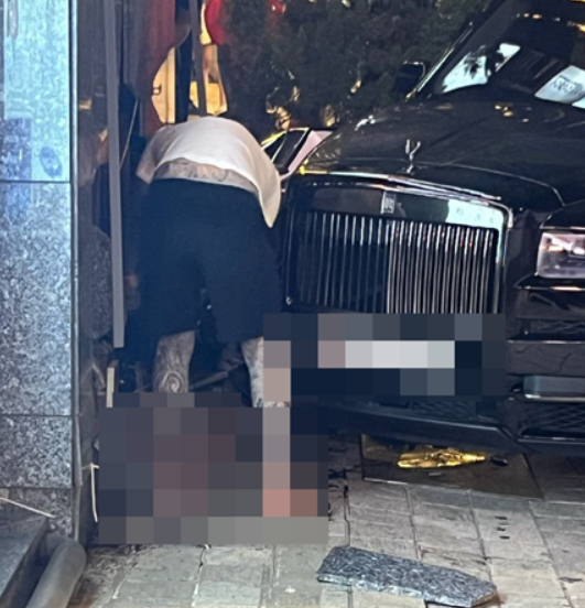 Driver checks on a woman he ran over with his Rolls-Royce in Apgujeong, southern Seoul, on Aug. 2. [JOONGANG PHOTO]
