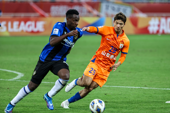 Chen Pu of Shandong Taishan, right, vies with Paul Jose M'poku of Incheon United during an AFC Champions League Group G match at Jinan Olympic Sports Center in Jinan, China on Tuesday. [XINHUA/YONHAP] 