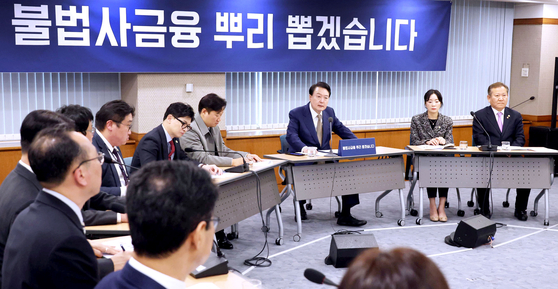 President Yoon Suk Yeol pledges to crack down on illegal private lenders in a meeting at the the Financial Supervisory Service (FSS) in Yeouido, western Seoul, on Thursday. [JOINT PRESS CORPS] 