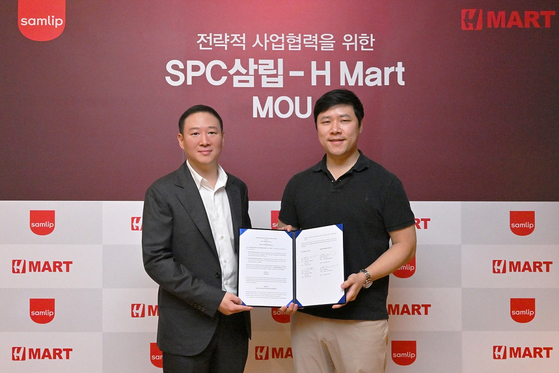 SPC Group Executive Vice President Hur Hee-soo, left, and H Mart CEO Brian Kwon, pose for a photo after signing an MOU for a strategic business partnership between the two companies last Friday. [SPC SAMLIP] 