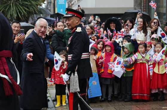 Charles is welcomed by the Korean community in New Malden, south-west London, England, on Wednesday. [EPA]