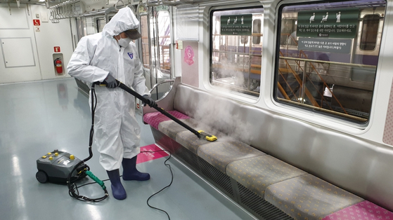 A worker hot-steams fabric seats on a subway in Seoul as part of an effort to control bedbug infestations in the country. [SEOUL METROPOLITAN GOVERNMENT]