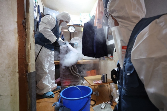 Workers from a community health center disinfect a room in Yongsan District, central Seoul, Thursday to prevent the spread of bedbugs. [YONHAP] 