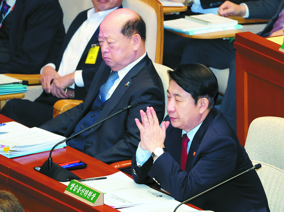 Lee Dong-kwan, chairman of the Korea Communications Commission (KCC), right, attends a meeting of the parliamentary Special Committee on Budget and Accounts at the National Assembly in western Seoul on Friday after the Democratic Party withdrew its motion to impeach him for the time being. [YONHAP]