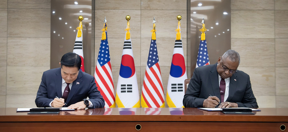 Korean Defense Minister Shin Won-sik, left, and U.S. Secretary of Defense Lloyd Austin take part in a signing ceremony of their newly revised tailored deterrence strategy at the Defense Ministry's headquarters in central Seoul on Monday. [DEFENSE MINISTRY]