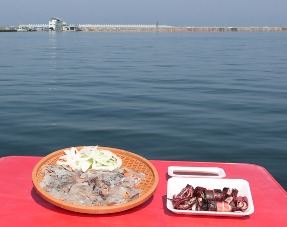 Squid dishes sold by seafood vendors in Gangwon. The left dish is raw sliced squid and the right is steamed squid. [KIM CHUN-SIK, JOONGANG PHOTO]