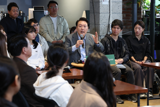 President Yoon Suk Yeol talks with small business owners, homemakers, office workers and younger adults at a cafe in Mapo District, western Seoul, on Nov. 1. [YONHAP]