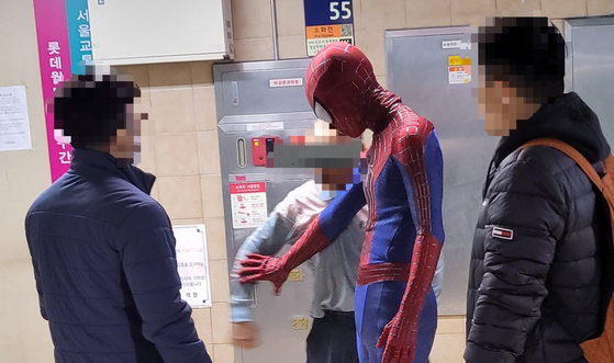 A man in his Spider-Man costume restrains a homeless person who is trying to swing his at subway workers on Saturday at Jamsil Station in southern Seoul. [SCREEN CAPTURE]