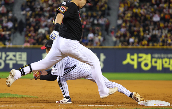 Shin Min-jae of the LG Twins catches the ball at first base ahead of Moon Sang-chul of the KT Wiz to secure the second out of a triple play in the second inning of the opening game of the 2023 Korean Series on Tuesday.  [YONHAP]