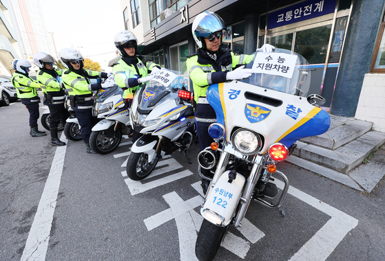 Two days before the Korean College Scholastic Ability Test (CSAT), police officers on Tuesday attach signs showing the bikes are reserved for special traffic control in Suwon, southern Gyeonggi. The police will offer rides to test-takers on Thursday morning.  The Gyeonggi Nambu Provincial Police Agency said that 2,091 officers and volunteers will be dispatched along with 390 police cars and motorcycles to ensure a smooth and silent traffic flow around testing sites. The authority will also crack down on illegally parked cars. [YONHAP] 