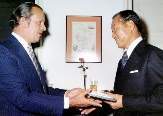 Hyundai Group founder Chung Ju-yung, right, receives the CBE award in 1977 by William Bates, British Ambassador to Korea at the time. [HYUNDAI MOTOR GROUP]