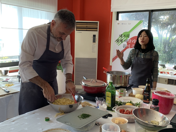 Chef Marco Ferrari, left, is leading a cooking class at the Italian Ambassador to Koreas residence in Yongsan District, central Seoul, on Tuesday, for the Week of Italian Cuisine in the World. [LEE JIAN]