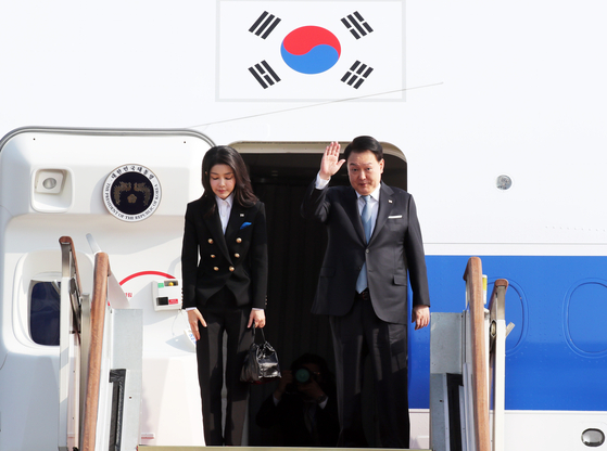 President Yoon Suk Yeol, right, waves alongside first lady Kim Keon Hee as they depart on the presidential jet from the Seoul Air Base in Seongnam, Gyeonggi, on Wednesday, beginning a four-day visit to San Francisco for the APEC leaders’ summit. [JOINT PRESS CORPS]