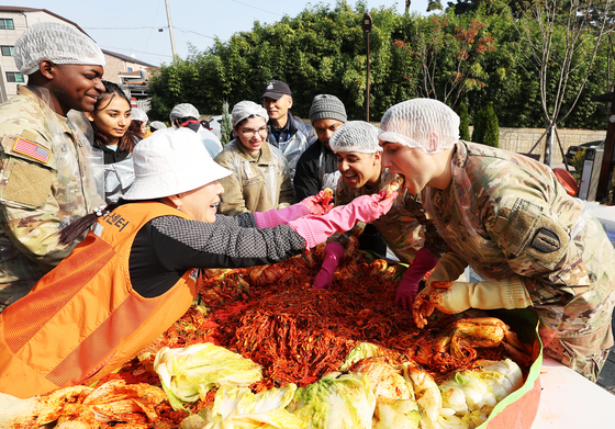 U.S. soldiers based in Korea taste freshly made kimchi on Wednesday morning at the community service center in Paengseong-eup, Pyeongtaek in Gyeonggi. The kimchi-making season, or kimjang, usually takes place before the arrival of winter. [YONHAP]