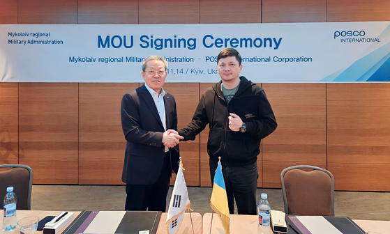 Posco International CEO Jeong Tak, left, and Governor Vitalii Kim of the Mykolaiv region pose for a photo during a signing ceremony on Tuesday in Kyiv for the company's modular construction business in Ukraine. [POSCO INTERNATIONAL]