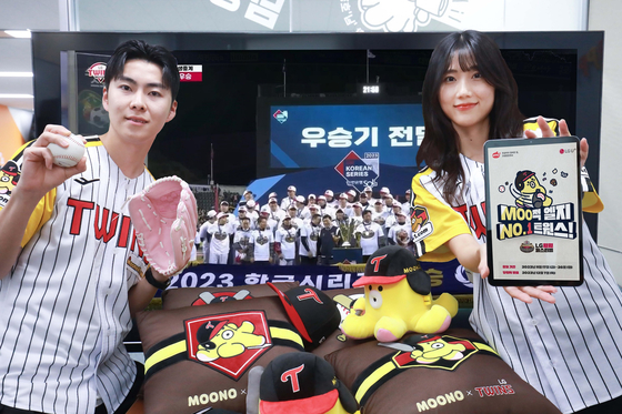 LG Uplus employees introduce the company’s promotions held in celebration of LG Twins Korea Series win. LG U+ announced a variety of events including free one year membership coupons for online streaming services and limited-edition merchandise on Thursday. [LG Uplus]
