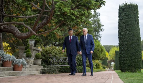 U.S. President Joe Biden and Chinese President Xi Jinping walk in the gardens at the Filoli Estate in Woodside, California., on Wednesday on the sidelines of the Asia-Pacific Economic Cooperative conference. [AP/YONHAP]
