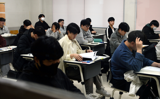 Test-takers wait to solve exam questions of the College Scholastic Ability Test on Thursday at Hanbat High School in Daejeon. [JOONGANG PHOTO]