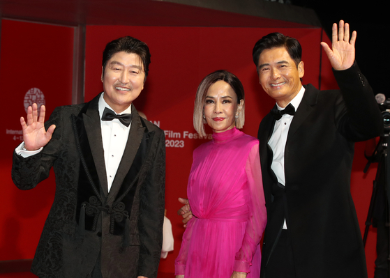 From left, actor Song Kang-ho, Hong Kong actor Chow Yun-fat's wife Jasmine Tan, and Chow pose for a photo at the red carpet event of the Busan International Film Festival at the Busan Cinema Center in Haeundae District, eastern Busan, on Wednesday. [NEWS1]