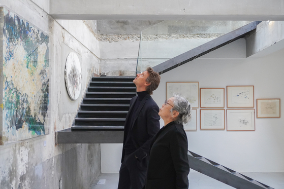 Arthur de Villepin, co-founder and chairman of gallery Villepin in Hong Kong, left, and Korean artist Myonghi Kang, look at Kang's artwork in Kir, a studio in Seongsu-dong of Seongdong District, eastern Seoul, where Kang's solo exhibit "The Colors of Time is being held. [VILLEPIN]