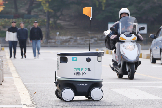 Autonomous mobile robot “Neubie” moves around the Konkuk University Seoul Campus in Gwangjin District, eastern Seoul on Tuesday. Neubie primarily delivers food with the help of an algorithm that calculates the fastest route based on its data system, which includes information on entrances, exits, stairs and slopes. [YONHAP]