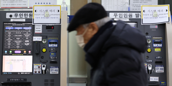 Notices of a system crash posted on an automated civil service machine at a district office in Seoul on Friday. Many people had trouble printing out government documents that were necessary in applying for loans and event library cards. [YONHAP]