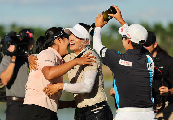 Friends hug Korea's Amy Yang, center, as Kim Hyo-joo to Yang's right douses her with champagne after her final putt on the 18th green during the last round of the CME Group Tour Championship at Tiburon Golf Club on Sunday in Naples, Florida. [AFP/YONHAP]