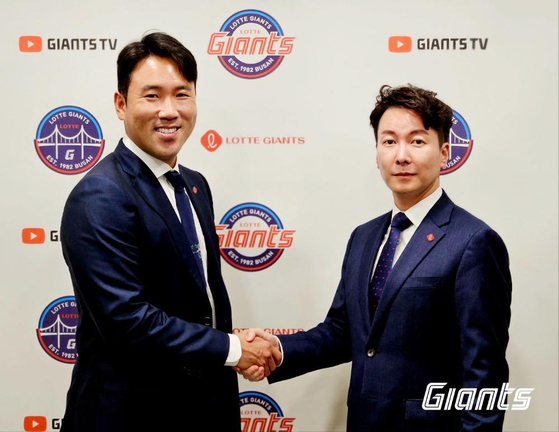 Lotte Giants outfielder Jeon Jun-woo poses for a photo with General Manager Park Jun-hyuk after re-signing with the club on Monday.  [YONHAP]