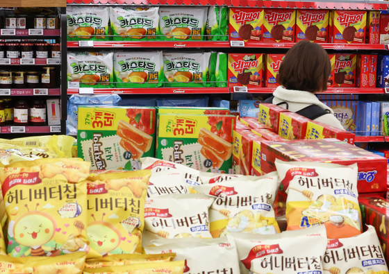 A shopper browses the snack aisle at a mart in Seoul on Sunday. The Korean government announced it will conduct a study on the so-called shrinkflation, which refers to when companies reduce the content size of a product while maintaining the same sticker price. [YONHAP]