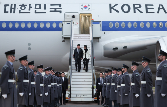 Korean President Yoon Suk Yeol, left, and first lady Kim Keon Hee are greeted by an honor guard as they arrive at London Stansted Airport on Monday for a four-day state visit to Britain. [JOINT PRESS CORPS]