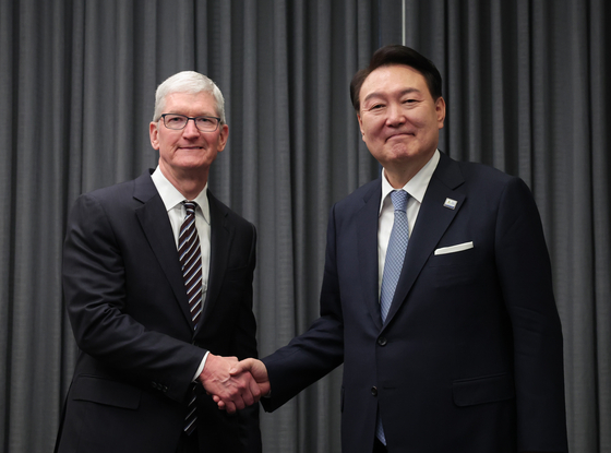 President Yoon Suk Yeol, right, shakes hands with Apple CEO Tim Cook on the sidelines of the APEC summit in San Francisco on Wednesday. [PRESIDENTIAL OFFICE]