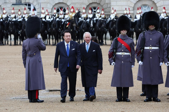 Korean President Yoon Suk Yeol, center left, and King Charles, center right, inspect troops on Horse Guards Parade in London on Britain during an official welcome ceremony Tuesday. The visit by the Korean leader marks the first state visit hosted by Britain since King Charles' coronation. [JOINT PRESS CORPS]