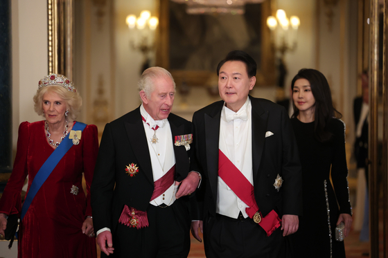 Korea's President Yoon Suk Yeol, center right, accompanied by first lady Kim Keon Hee, and Britain's King Charles III, center left, with Queen Camilla enter the ballroom for a state banquet at Buckingham Palace in central London on Tuesday evening. [JOINT PRESS CORPS]