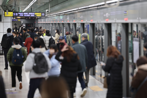 Commuters walk on the platform at Gwanghwamun Station in central Seoul on Tuesday. The labor union of Seoul Metro reached an agreement with the subway operator on Tuesday, withdrawing its plans to go on strike on Wednesday. [YONHAP]
