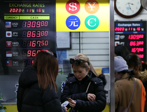 People wait in line to convert currency at a currency exchange shop in Myeong-dong in central Seoul on Nov. 16. [NEWS1]