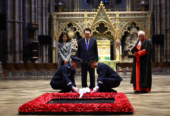 Korea's President Yoon Suk Yeol and first lady Kim Keon Hee watch as a wreath is placed at the Grave of the Unknown Warrior at Westminster Abbey in central London on Tuesday during their state visit to London. [AFP)/YONHAP]