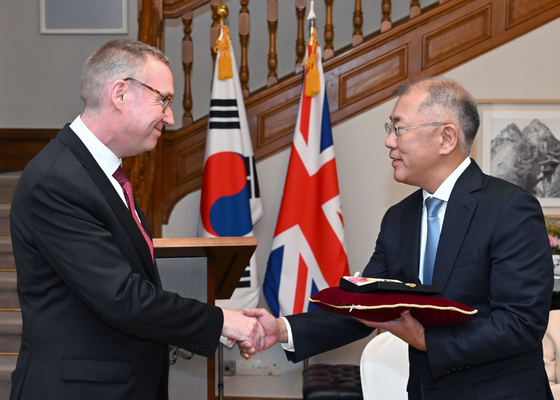 Hyundai Motor Group Chair Euisun Chung, right, receives the Commander of the Most Excellent Order of the British Empire presented by British Ambassador to Korea Colin Crooks on Tuesday at the embassy in central Seoul. [HYUNDAI MOTOR GROUP]
