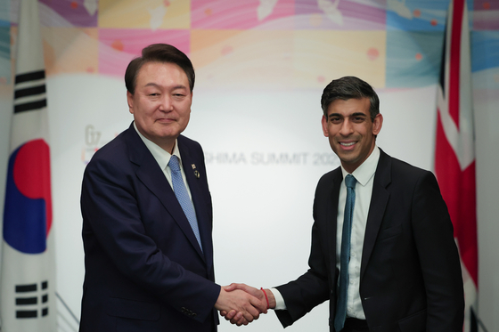 Korean President Yoon Suk Yeol, left, and British Prime Minister Rishi Sunak shake hands during their bilateral summit at the G7 gathering in Hiroshima, Japan, on May 20. [PRESIDENTIAL OFFICE]