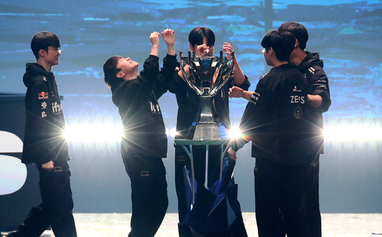 Members of Korea's T1 celebrate on stage after defeating Chinese team Weibo Gaming 3-0 to win the 2023 League of Legends World Championship on Sunday in Seoul. [JOINT PRESS CORPS]