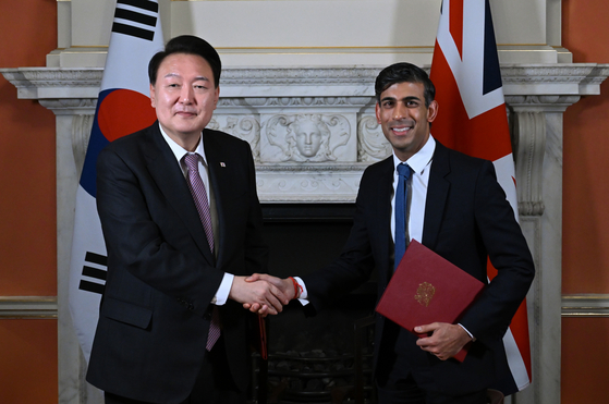 Korean President Yoon Suk Yeol, left, and British Prime Minister Rishi Sunak shake hands after signing the ″Downing Street Accord″ during their bilateral summit at 10 Downing Street in London on Wednesday. [JOINT PRESS CORPS]