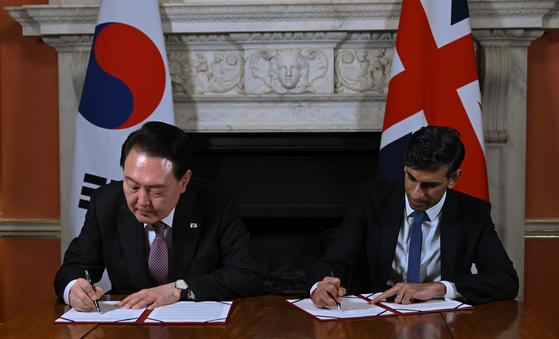 Korean President Yoon Suk Yeol, left, and British Prime Minister Rishi Sunak sign the ″Downing Street Accord″ during their bilateral summit at 10 Downing Street in London on Wednesday. [JOINT PRESS CORPS]