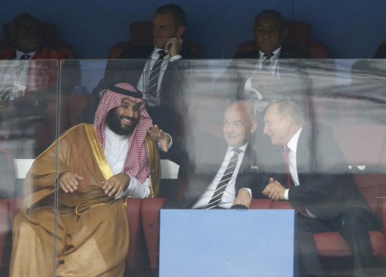 Saudi Arabia Crown Prince Mohammed bin Salman, left, FIFA President Gianni Infantino, center, and Russian President Vladimir Putin watch the match between Russia and Saudi Arabia which opens the 2018 soccer World Cup at the Luzhniki stadium in Moscow, Russia, on June 14, 2018. [AP]